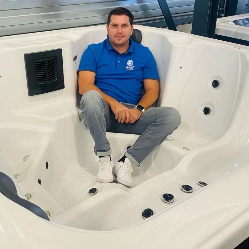 Selwin zit in een spa in de showroom van Spaweb in Almelo